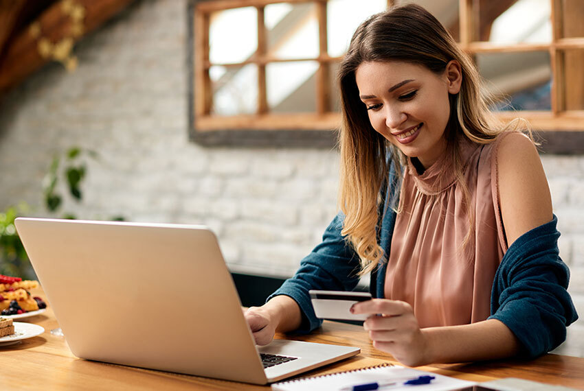 Woman in Sleeveless Dress Holding Credit Card While Paying Online Bill