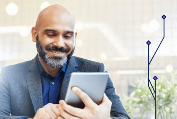 Man in Suit Jacket Smiling While Looking at Tablet