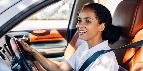 Woman smiling driving car