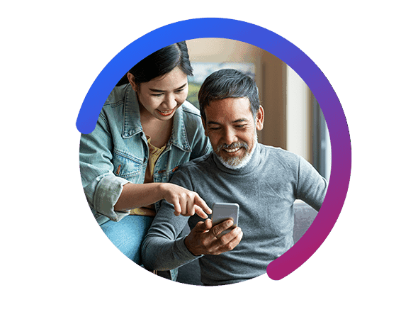 Woman and Man Smile While She Points at Smart Phone