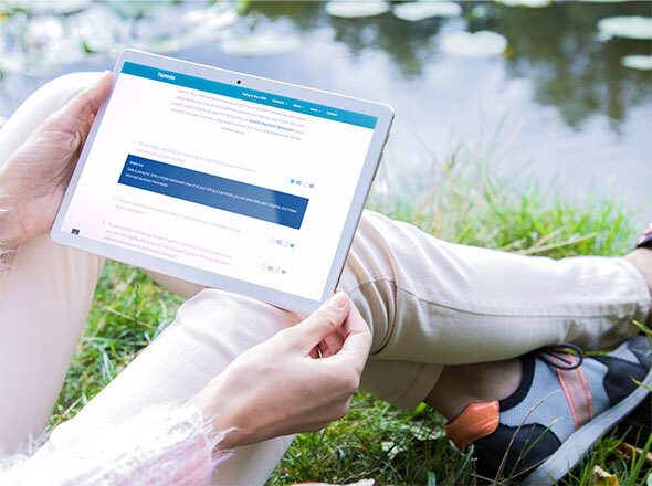 Woman Sitting by River Taking a Quiz on Tablet