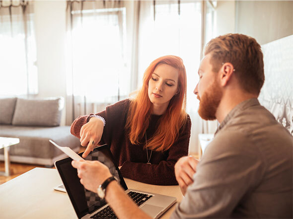 Man and Woman Sitting in Front of Laptop Addressing Finances