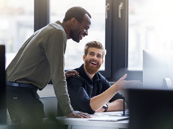 Coworkers Looking at a Computer and Smiling