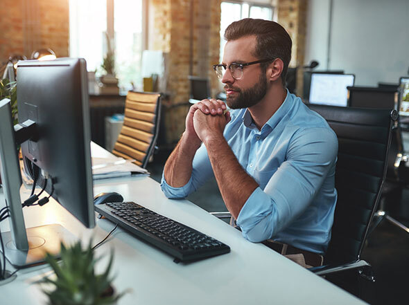Man in Blue Button Up Shirt Concentrating on Computer Screen