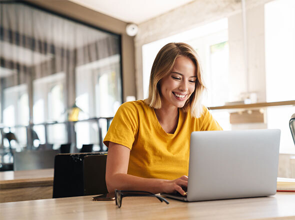 Woman in office smiling at laptop