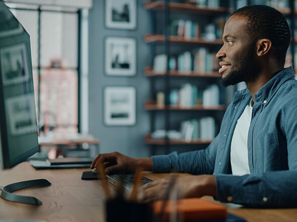 Man at Home Sitting at Desk Working Remotely