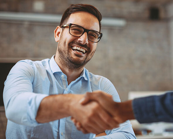 Man in Blue Button Down Shirt and Glasses Smiling and Shaking Hands