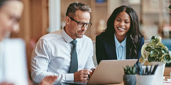 Coworkers sitting around laptop