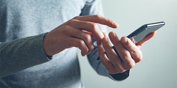 Male Hands Holding Cell Phone