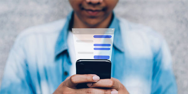 Man in Denim Shirt Using Cellphone with an Overlay Showing Virtual Chat